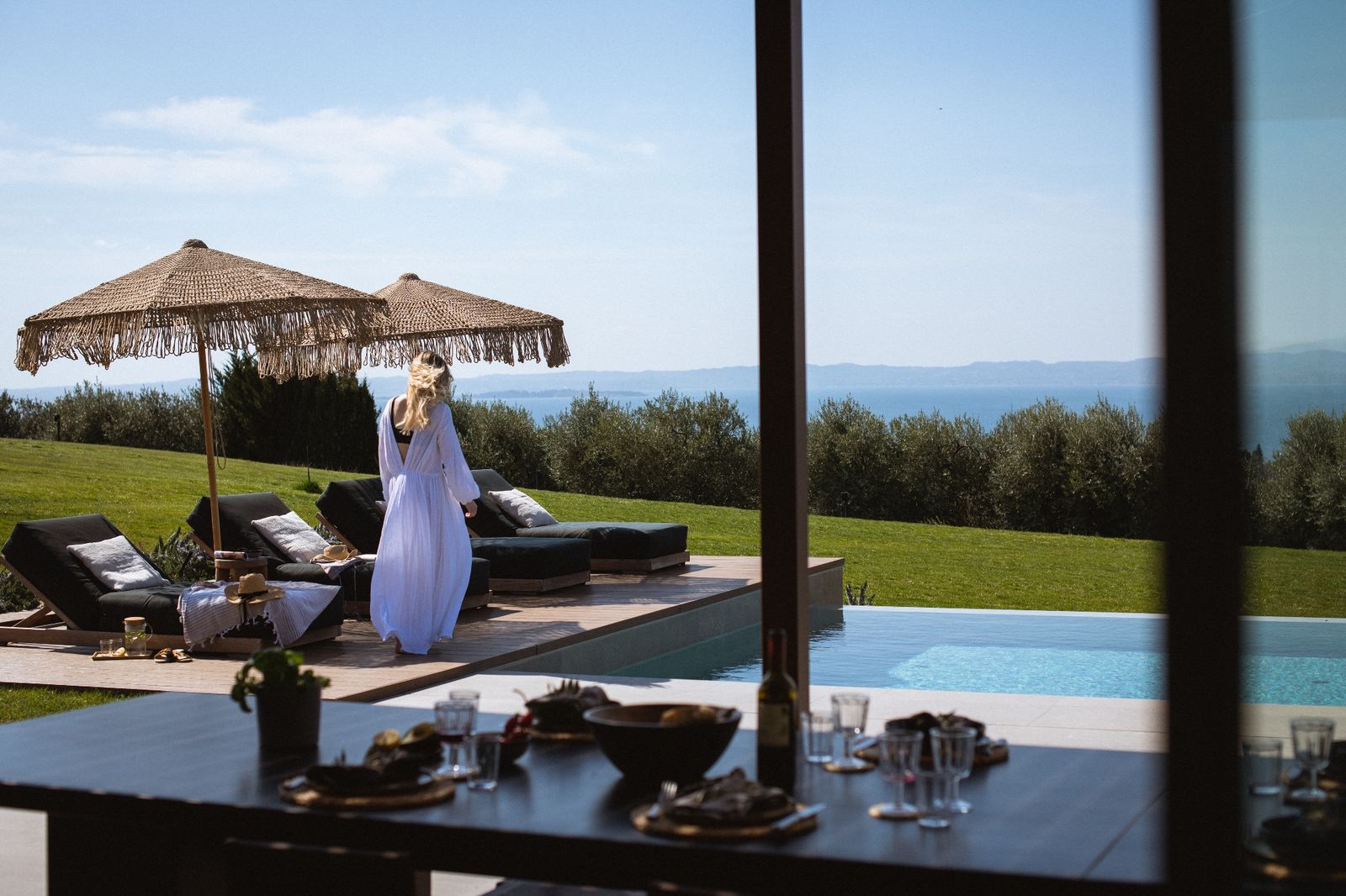 Terrasse mit Sonnenschirm und Poolblick