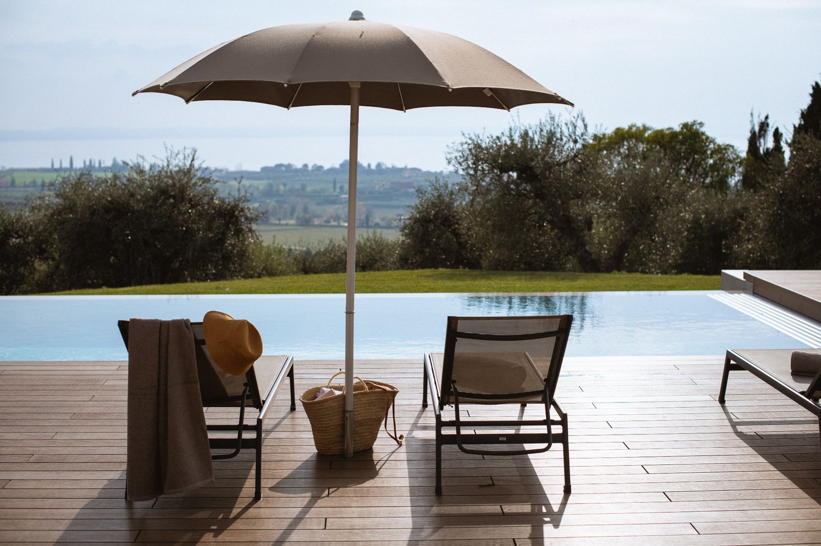 Sonnenschirm und Liegen am Pool der Villa Cavaion